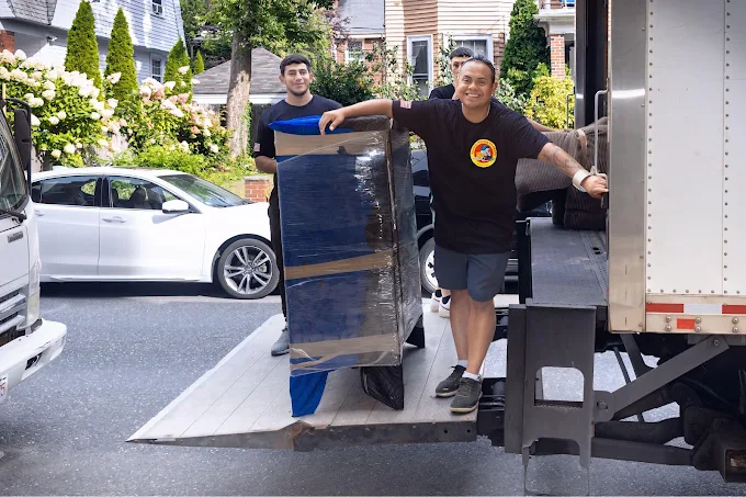 Speedy movers loading protected furniture into a moving truck
